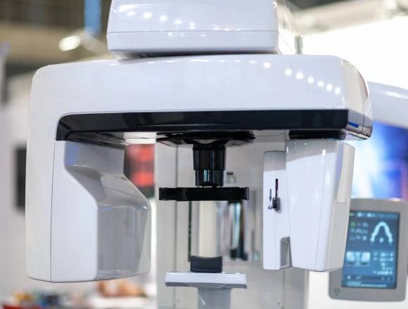 Dental laboratory analyzer machine with white exterior and black internal components on display counter.