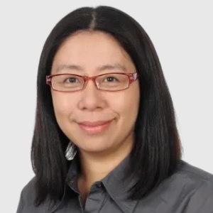Professional headshot of an Asian woman wearing glasses and dark shirt against neutral background.